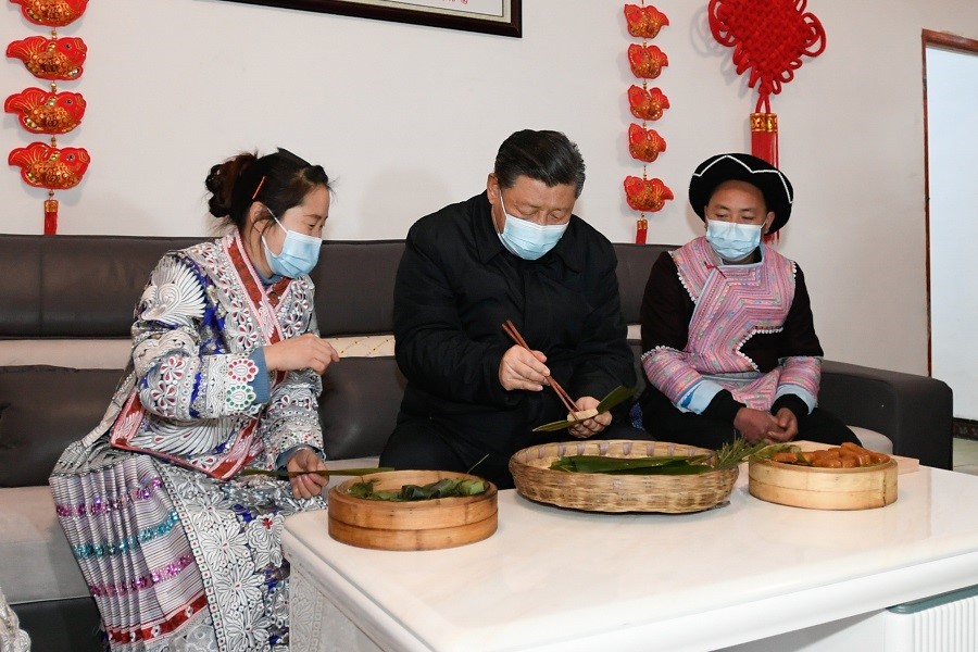 2021年2月3日下午，習近平在貴州畢節(jié)市黔西縣新仁苗族鄉(xiāng)化屋村苗族村民趙玉學家，同一家人邊聊家常邊制作當?shù)貍鹘y(tǒng)節(jié)日食品黃粑。新華社記者 李學仁 攝